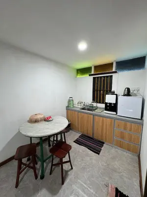 a kitchen with a table and two chairs and a counter at Rumah Inap Kampung Agong Tempua in Penaga