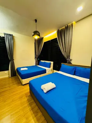two beds in a room with blue sheets and curtains at Private Pool Villa Near Batu Ferringhi Beach in Batu Ferringhi
