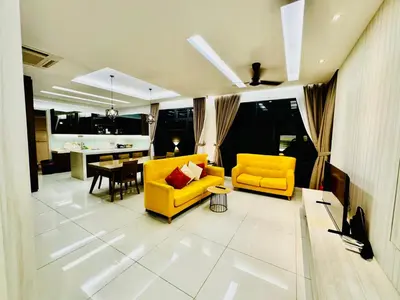 a living room with two yellow chairs and a table at Private Pool Villa Near Batu Ferringhi Beach in Batu Ferringhi