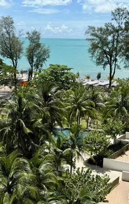 a view of a beach with palm trees and the ocean at By The Sea Batu Ferringhi, Penang Beach in Batu Ferringhi