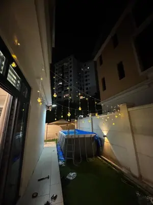 a balcony with a table and lights at night at Batu Ferringhi Home Near Beach in Penang with private pool in Batu Ferringhi
