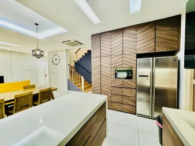 a kitchen with a stainless steel refrigerator and a table at Batu Ferringhi Home Near Beach in Penang with private pool in Batu Ferringhi