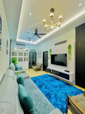 a living room with a large blue rug at Homestay Deedora 87 in Seri Manjung