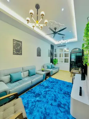 a living room with a couch and a blue rug at Homestay Deedora 87 in Seri Manjung