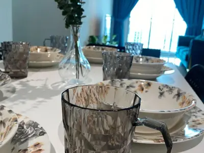 a table with plates and a glass mug on it at Galaxy Luxury Homestay in Bukit Mertajam