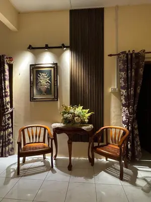 a room with two chairs and a table with flowers on it at Casa de' Sara Pool Homestay Ipoh in Ipoh