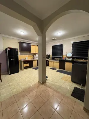a large kitchen with a black refrigerator and counters at Casa de' Sara Pool Homestay Ipoh in Ipoh