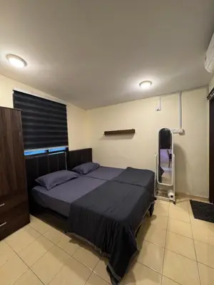 a bedroom with a bed and a chair in it at Casa de' Sara Pool Homestay Ipoh in Ipoh
