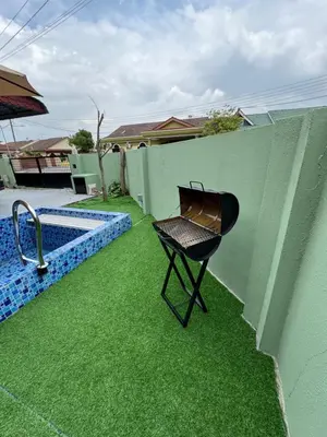 a chair sitting on the grass next to a swimming pool at Casa de' Sara Pool Homestay Ipoh in Ipoh
