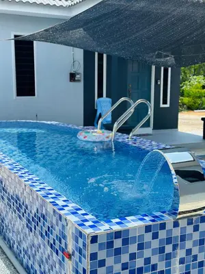 a swimming pool with a blue and white tiled at Che Puan Homestay Baling - 2 unit house with kids pool in Baling