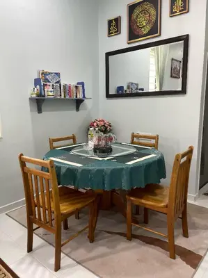 a dining room table with a green table cloth and two chairs at Che Puan Homestay Baling - 2 unit house with kids pool in Baling