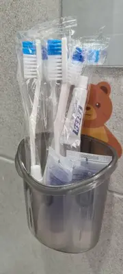 a container with toothbrushes and a teddy bear in it at Georgetown Penang - Skyline at Urban Suites - Affordable-Luxury-Cozy Stays with Sea and City Views in Jelutong