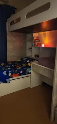 a bedroom with a bunk bed and a desk at Homestay Ummi Baling in Baling
