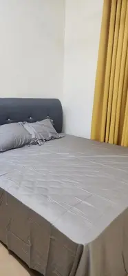 a bed in a room with yellow curtains at Homestay Ummi Baling in Baling