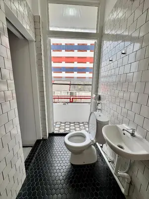 a bathroom with a toilet and a sink and a window at The Harbour by Moonknight in George Town