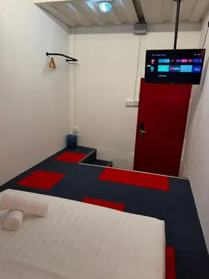 a room with a bed and a red door at The Harbour by Moonknight in George Town