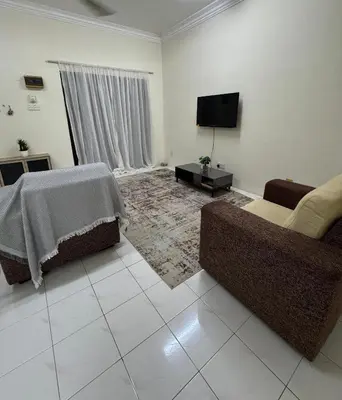 a living room with two couches and a flat screen tv at Teratai Bunda Homestay Tambun in Tambun