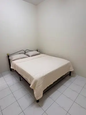a bed in a room with a white wall at Teratai Bunda Homestay Tambun in Tambun