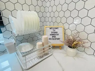 a white tiled counter top with a sign and some dishes at Diyans Homestay Ipoh in Ipoh