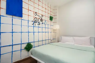a bed in a room with a tiled wall at A Cozy Place Penang in George Town