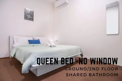 a white bedroom with a bed with a sign that reads queen bed no window ground at A Cozy Place Penang in George Town
