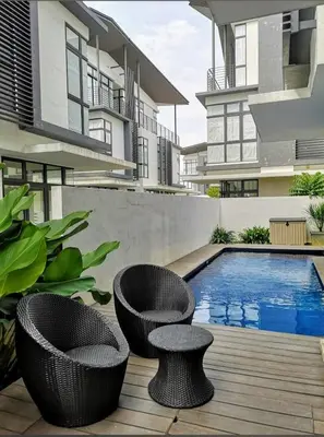 an apartment patio with two chairs and a swimming pool at super hotel in Gua Sai