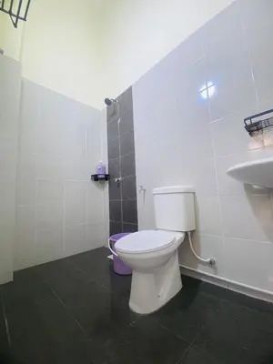 a bathroom with a white toilet and a sink at Diyyans Homestay Ipoh in Ipoh