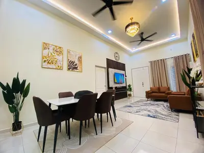 a living room with a table and chairs and a television at Diyyans Homestay Ipoh in Ipoh