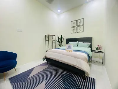a bedroom with a bed and a blue chair at Diyyans Homestay Ipoh in Ipoh