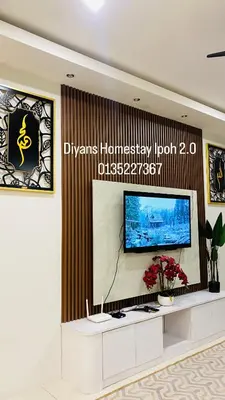 a living room with a flat screen tv on a wall at Deeyans Homestay Ipoh in Ipoh
