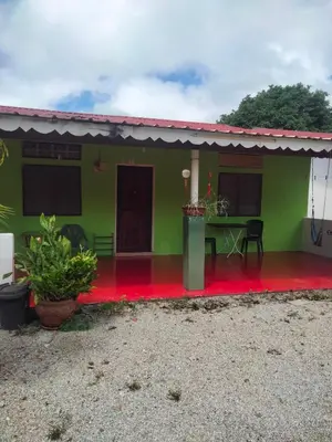 a green house with a red floor at Rainbow Villas in Gua Sai