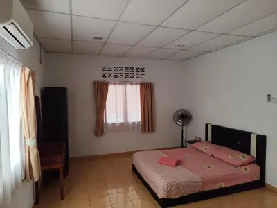 a bedroom with a bed with pink sheets and a window at Rainbow Villas in Gua Sai