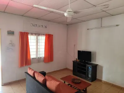 a living room with a couch and a tv at Rainbow Villas in Gua Sai