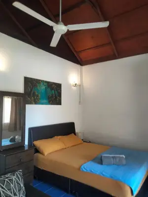 a bedroom with a bed and a ceiling fan at Rainbow Villas in Gua Sai