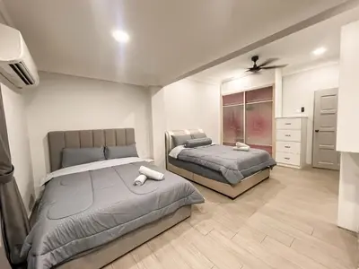 a bedroom with two beds and a dresser at Capybara Kids House 12 Pax 5 min to Ipoh Town in Ipoh