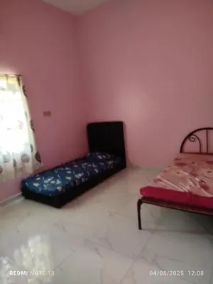 a room with a couch in the corner of a room at Homestay Usrati in Taiping