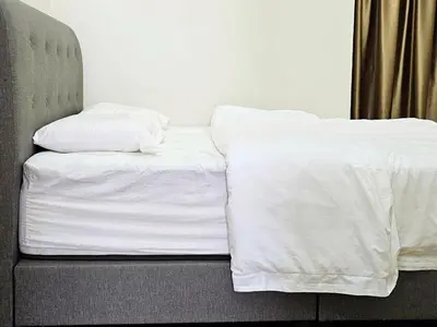a bed with white sheets and pillows on it at 14\u697c\u53cc\u5c42\u7a7a\u4e2d\u522b\u5885 Double Storey Penthouse Spacious Common Space for Gathering in Sekincan