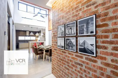 a brick wall with pictures on it next to a dining room at Yenny Cottage - Canning Private House Spacious in Ipoh