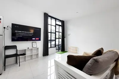 a living room with a couch and a tv on a wall at Casa Bella - Private Studio Ipoh - Pet allowed in Ipoh