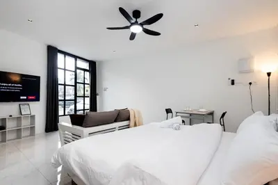 a white bedroom with a bed and a ceiling fan at Casa Bella - Private Studio Ipoh - Pet allowed in Ipoh
