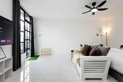 a white bedroom with a bed and a ceiling fan at Casa Bella - Private Studio Ipoh - Pet allowed in Ipoh