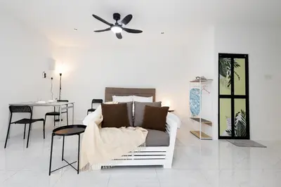 a white living room with a couch and a ceiling fan at Casa Bella - Private Studio Ipoh - Pet allowed in Ipoh