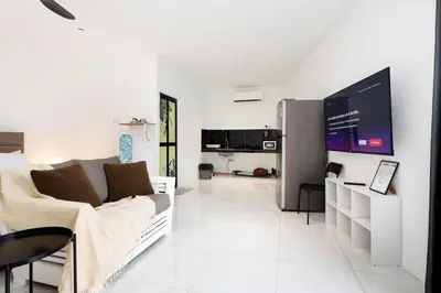a white living room with a couch and a tv at Casa Bella - Private Studio Ipoh - Pet allowed in Ipoh