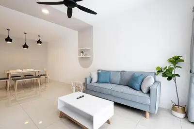 a living room with a blue couch and a table at Arctic Breeze - Pengkalan WaterPark Pool Gym in Ipoh