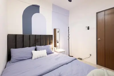 a bedroom with a large bed with blue pillows at Arctic Breeze - Pengkalan WaterPark Pool Gym in Ipoh