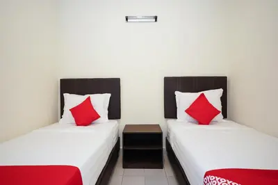two beds in a room with red pillows at Dancenter Near Petronas Kampung Koh, Jj Hotel in Kampung Koh