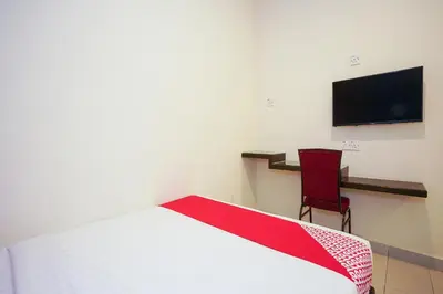 a bedroom with a bed and a chair and a tv at Dancenter Near Petronas Kampung Koh, Jj Hotel in Kampung Koh