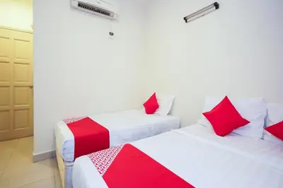 two beds in a room with red and white sheets at Dancenter Near Petronas Kampung Koh, Jj Hotel in Kampung Koh