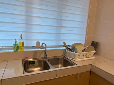 a kitchen sink with a dish drying rack next to a window at Ipoh Modern Family Retreat in Ipoh
