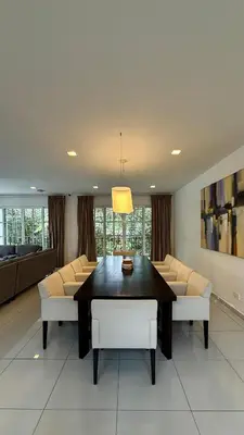 a dining room with a table and white chairs at Riverview Bungalow in Cameron Highlands in Tanah Rata